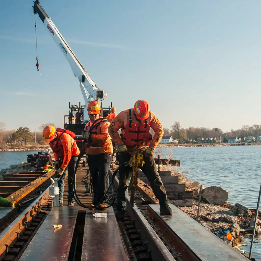 Workers on bridge with crane nearby.