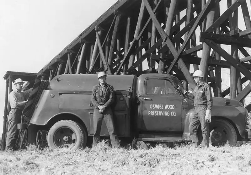 Vintage truck near wooden structure.